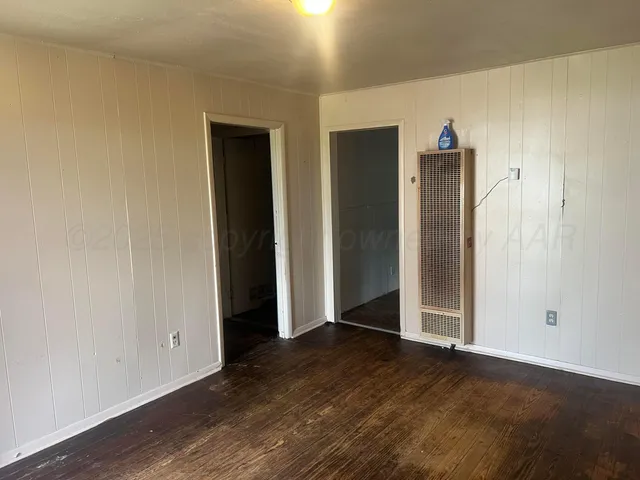 an empty room with wooden floor and closet