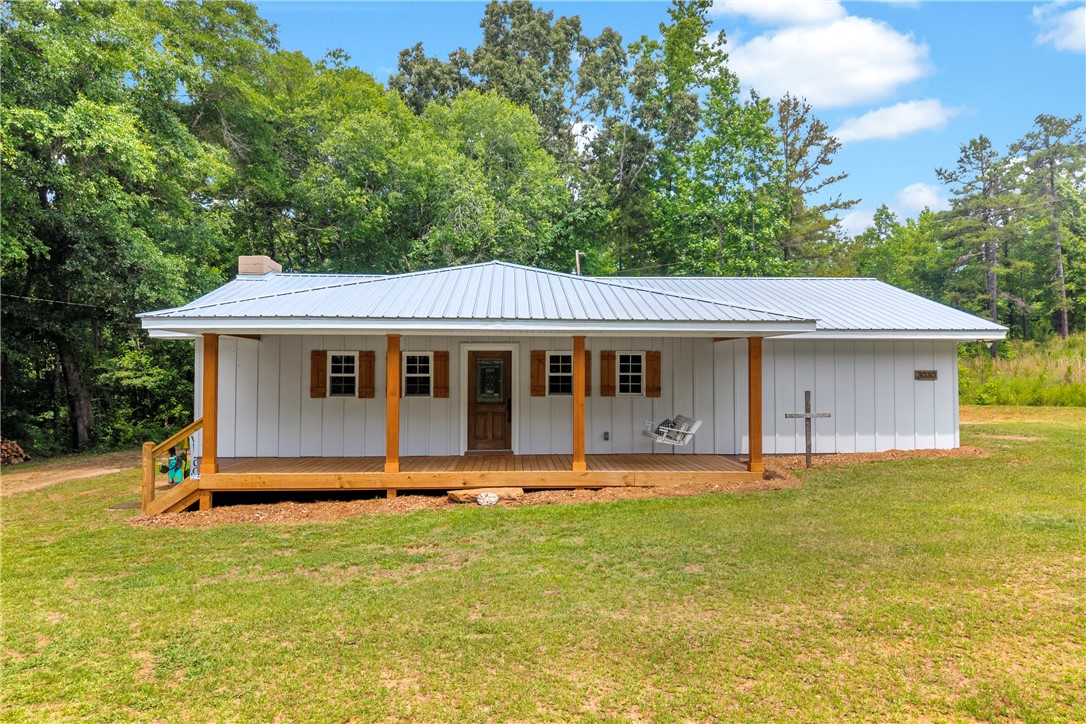 3030 Smith McGee Road Iva, SC 29655 - Photo 1 of 46 A welcoming front porch extends across this charming white home with a metal roof.