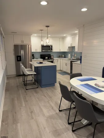 a kitchen with stainless steel appliances kitchen island granite countertop a sink and cabinets