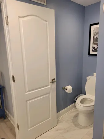 a white toilet sitting next to a shower