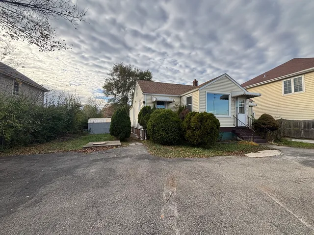 a view of a house with a yard and large tree
