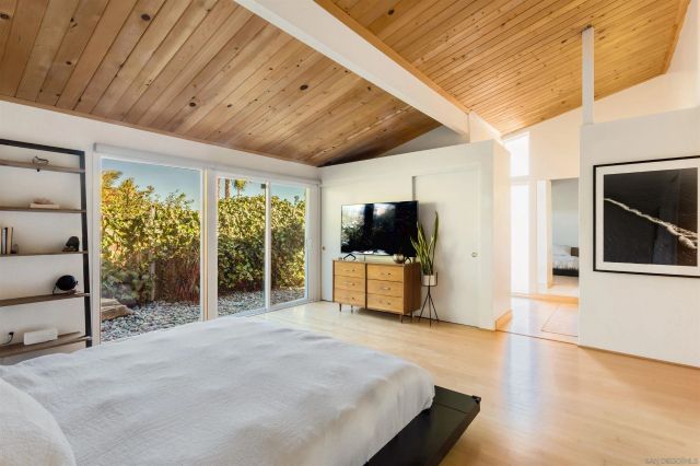 a bedroom with furniture and a flat screen tv