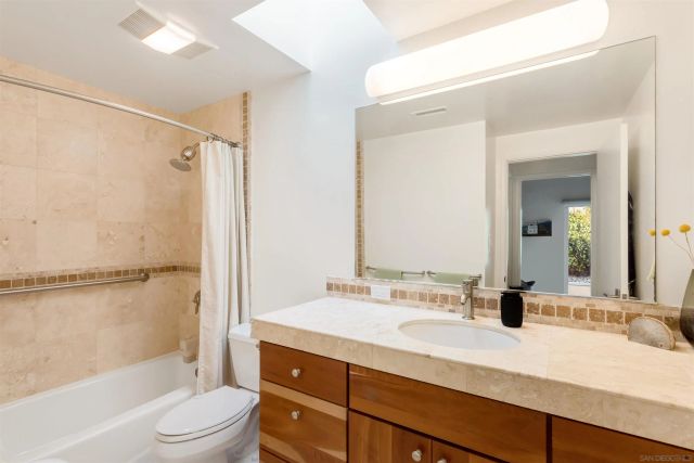a bathroom with a granite countertop sink toilet tub and shower