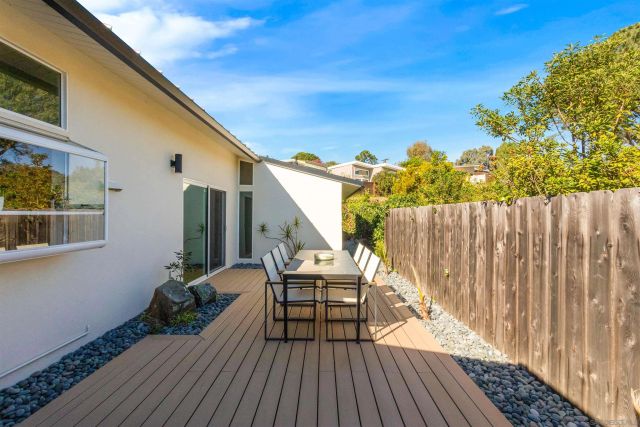 a balcony with wooden floor table and chairs