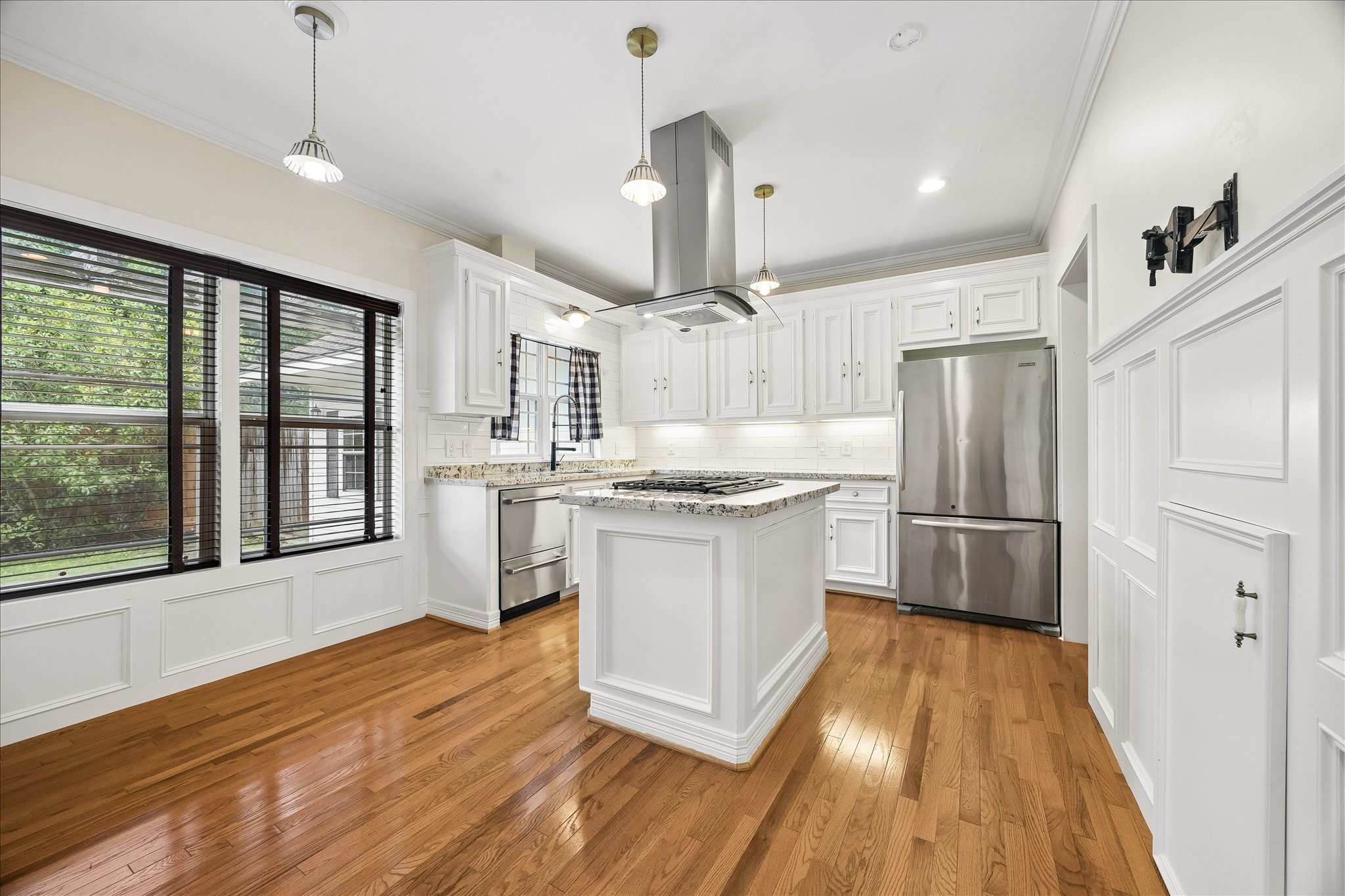 3231 North MacGregor Way Houston, TX 77004 - Photo 9 of 22 Bright, modern kitchen featuring granite countertops, a built-in island range, included refrigerator, and an abundance of natural light