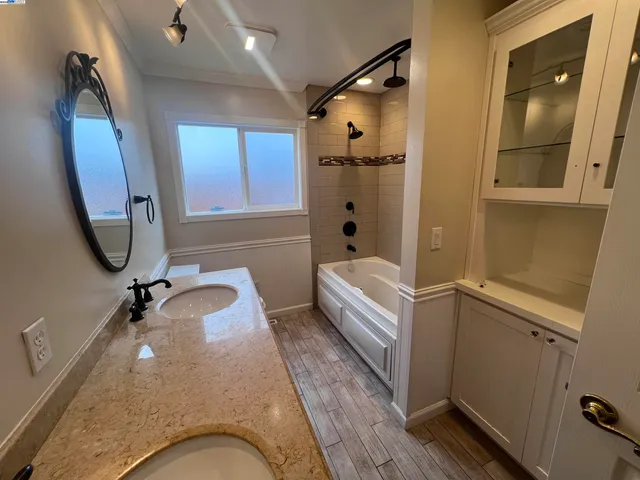 a bathroom with a tub sink and mirror