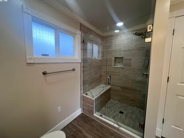 a bathroom with a granite countertop sink a mirror and shower