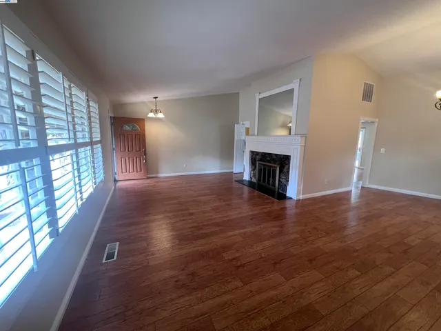 a view of a livingroom with wooden floor and a fireplace