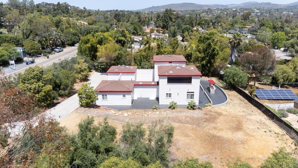 an aerial view of residential houses with outdoor space and trees