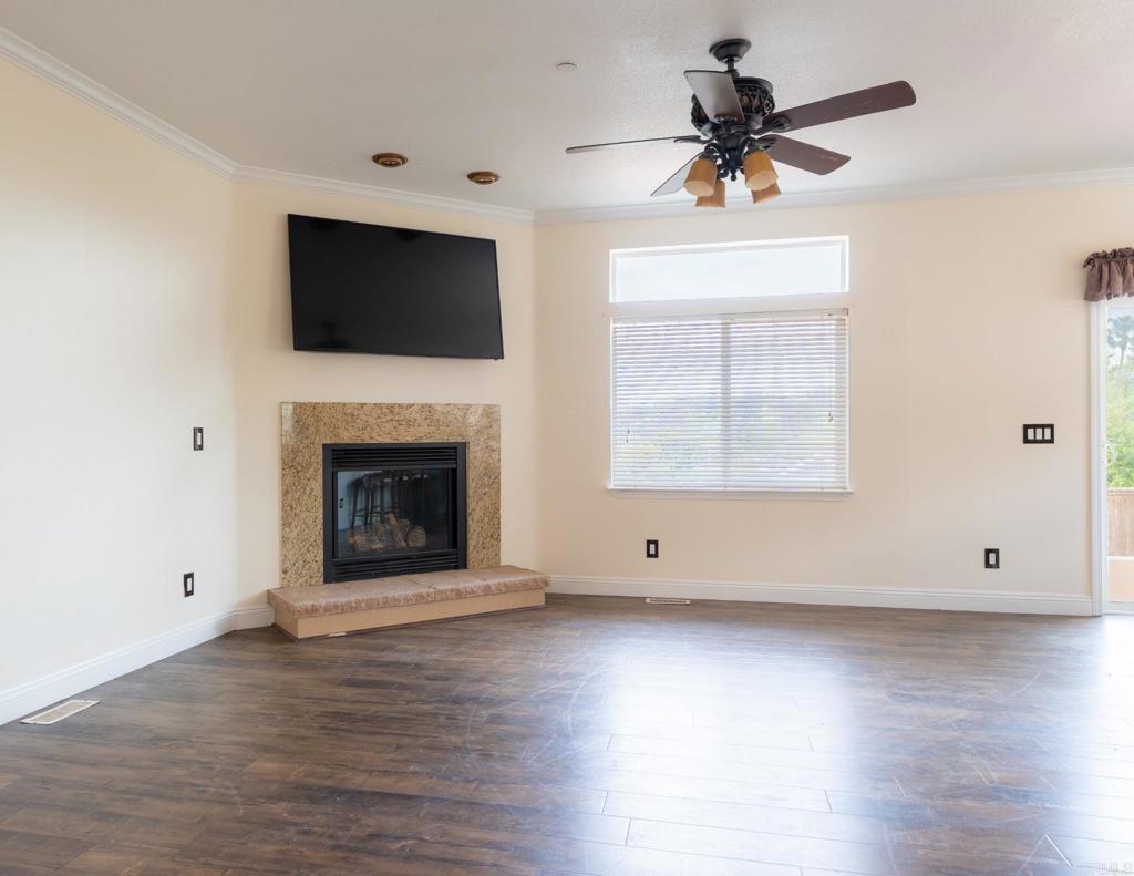 441 Rancho Santa Fe Road Encinitas, CA 92024 - Photo 7 of 17 a view of an empty room with wooden floor and a fireplace