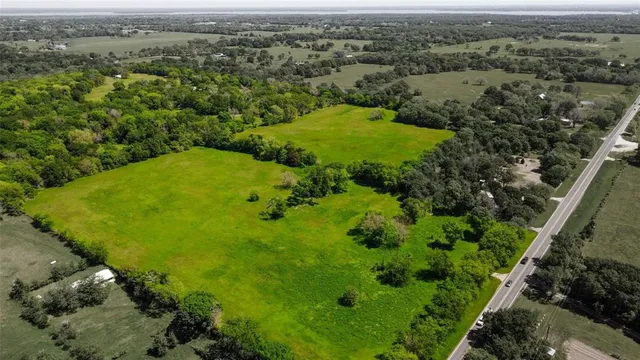 an aerial view of residential houses with outdoor space and trees