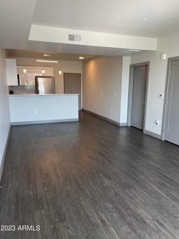a view of a big room with wooden floor and windows