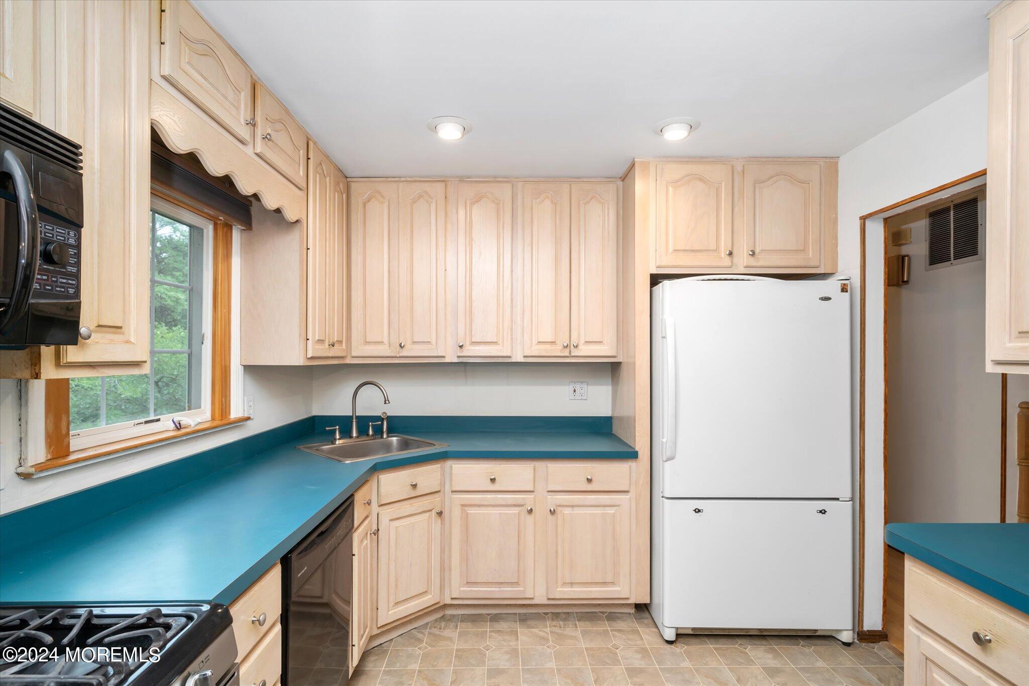 3720 River Road Point Pleasant, NJ 08742 - Photo 9 of 28 a kitchen with a refrigerator sink and cabinets