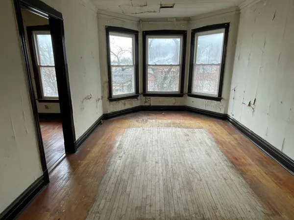 wooden floor in an empty room with a window
