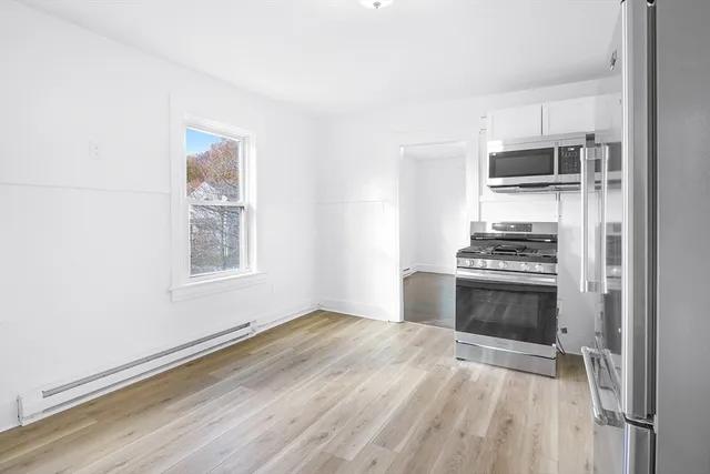 a kitchen with granite countertop a stove cabinets and microwave
