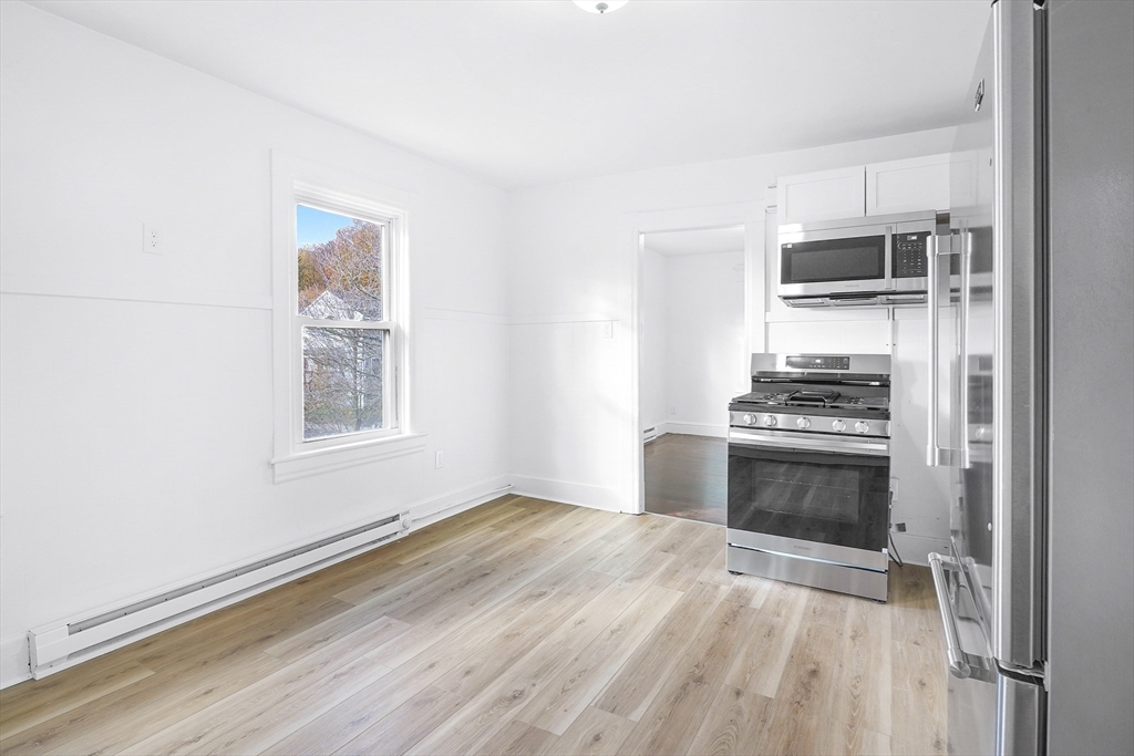 12 Temple Street Holyoke, MA 01040 - Photo 16 of 36 a kitchen with granite countertop a stove cabinets and microwave