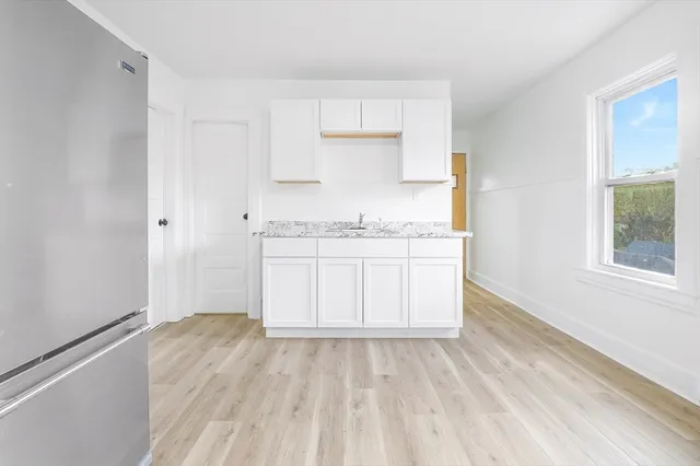 a view of a kitchen with a sink and dishwasher with wooden floor