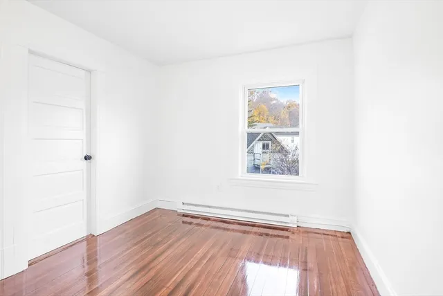 a view of a small space with wooden floor and a window
