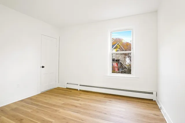 a view of a room with wooden floor and white walls