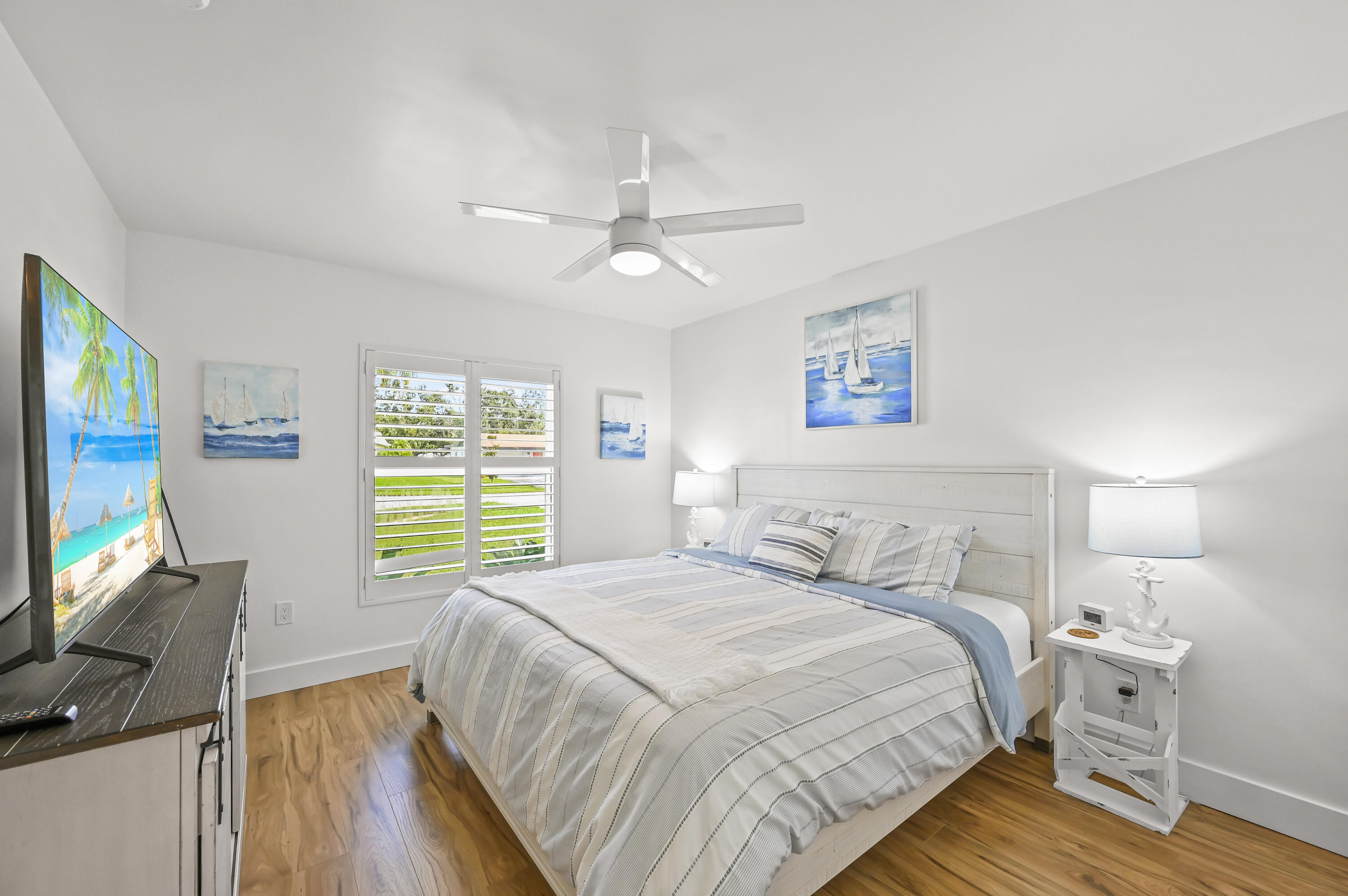 68 Azalea Circle Tequesta, FL 33469 - Photo 18 of 36 a bedroom with a bed a computer on the desk and a dresser next to a window
