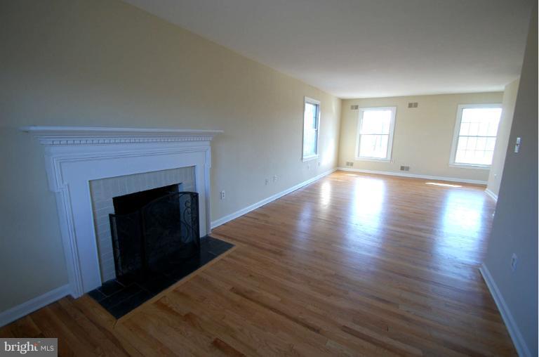 1904 Ednor Road Silver Spring, MD 20905 - Photo 14 of 30 a view of an empty room with wooden floor fireplace and a window