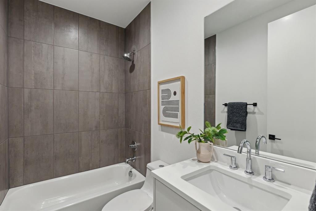 2142 Lovedale Avenue, Unit 104 Dallas, TX 75235 - Photo 28 of 29 a bathroom with a granite countertop sink a toilet a mirror and shower