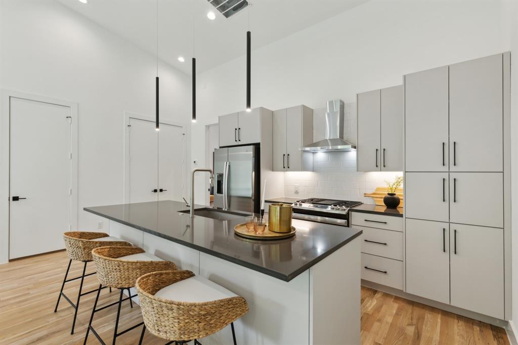 2142 Lovedale Avenue, Unit 104 Dallas, TX 75235 - Photo 7 of 29 a kitchen with kitchen island granite countertop a sink a stove and chairs