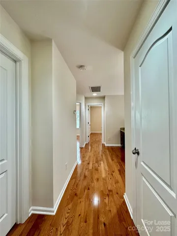 a view of a hallway with wooden floor and staircase