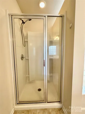 a bathroom with a glass shower door and a glass door