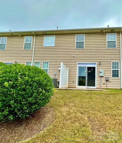 a view of a house with a yard and potted plants