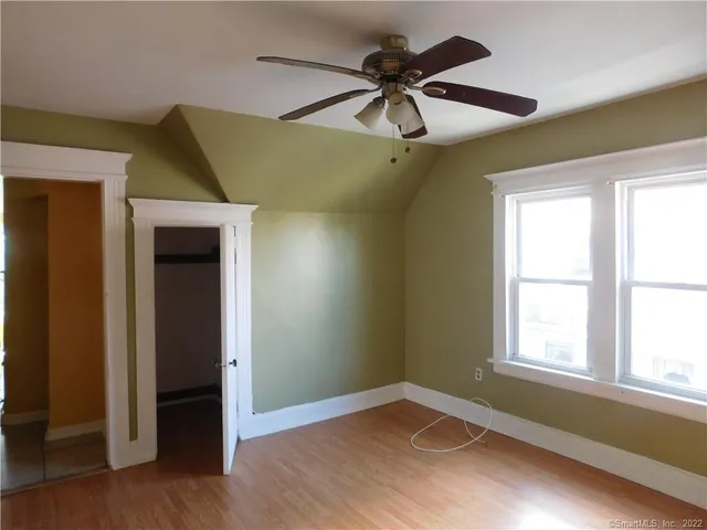 an empty room with a window and a ceiling fan