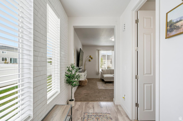 7685 Timber Country Road Eagle Mountain, UT 84005 - Photo 5 of 39 Bright entryway featuring wood-finish flooring and a white painted brick accent wall