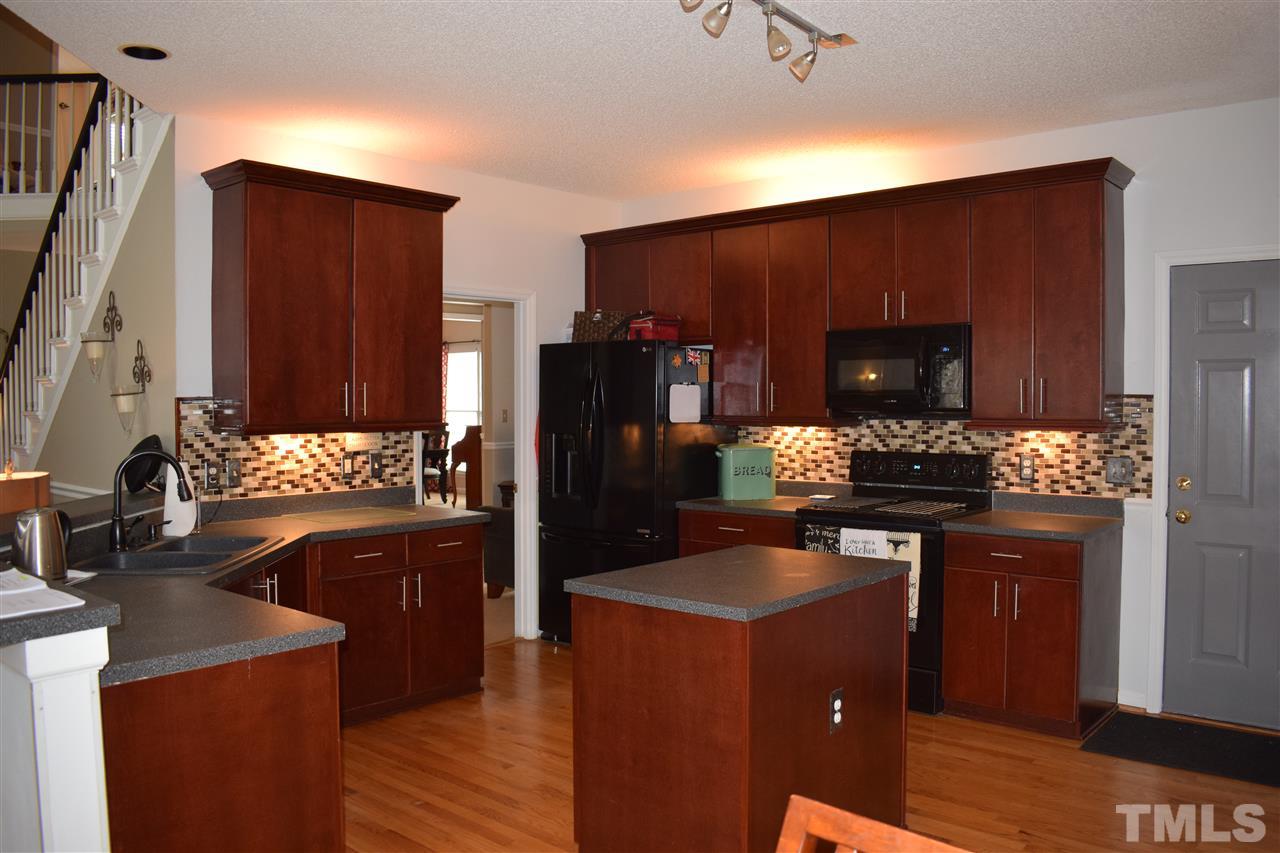 5200 Calverton Drive Raleigh, NC 27613 - Photo 2 of 25 Spacious kitchen with updated appliances, breakfast bar, island, tile backsplash & under/over cabinet lighting. Lots of cabinets & counter space.