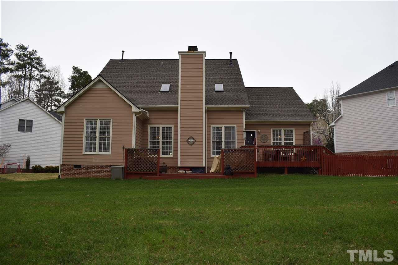 5200 Calverton Drive Raleigh, NC 27613 - Photo 24 of 25 Back of the house showing two tiered deck (lower deck is not permitted but not attached to the house). There is a fenced-in area with another patio on the right side perfect for pets.