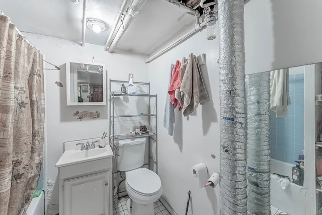 a bathroom with a toilet sink and shower curtain