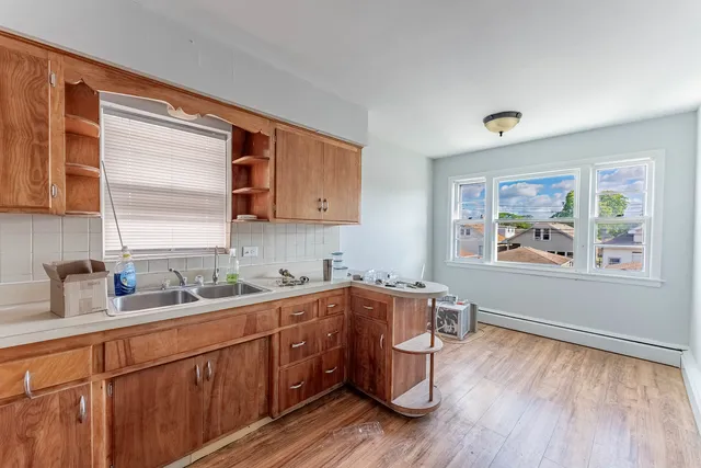 a kitchen with stainless steel appliances a sink cabinets and wooden floor