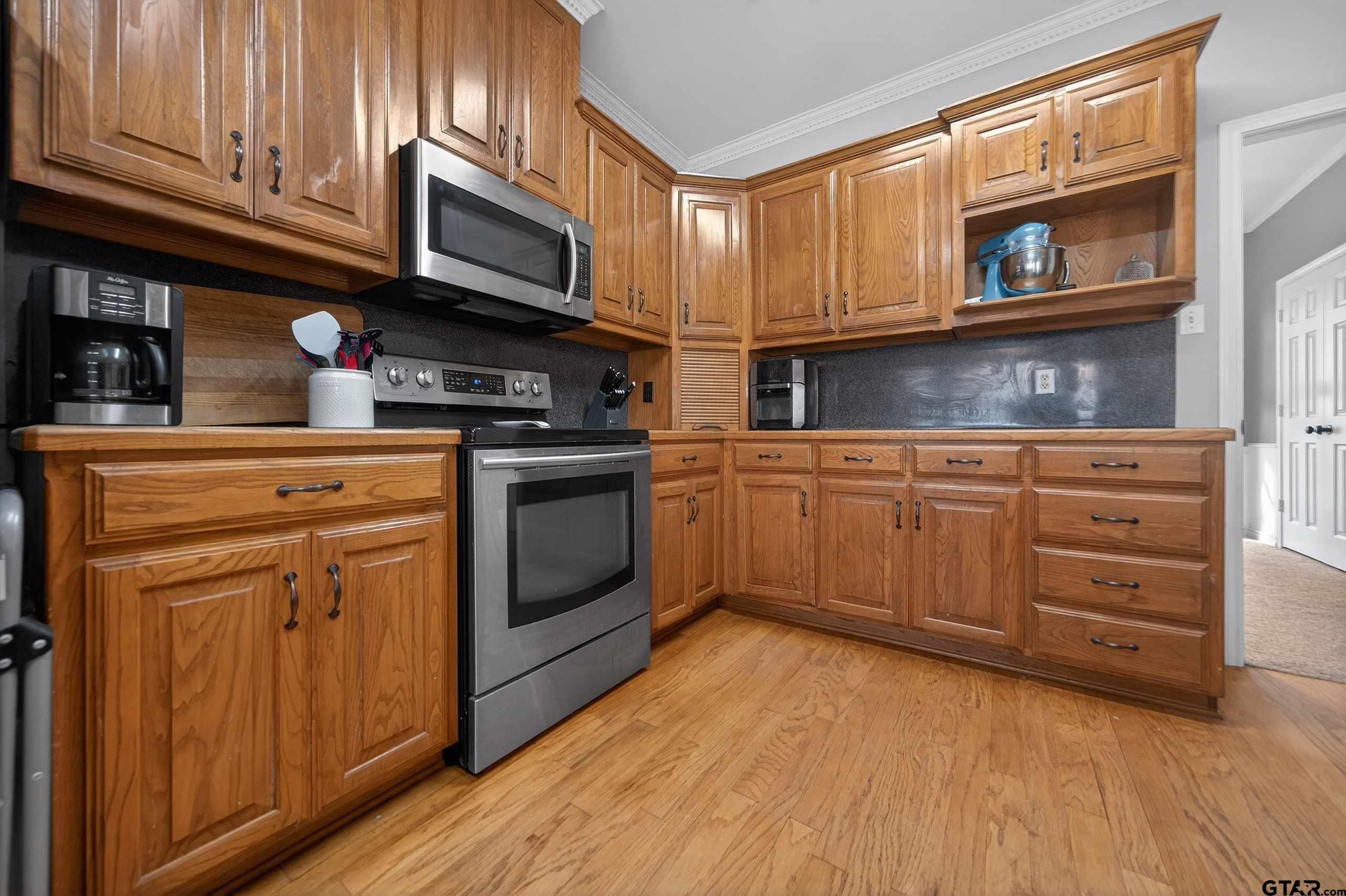 781 Highway 19 Edgewood, TX 75117 - Photo 19 of 48 a kitchen with stainless steel appliances granite countertop a stove microwave and cabinets