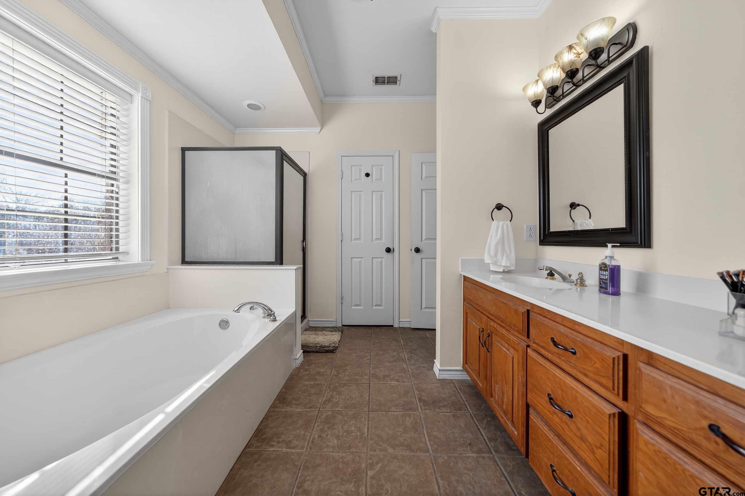 781 Highway 19 Edgewood, TX 75117 - Photo 36 of 48 a spacious bathroom with a tub double sink window and mirror