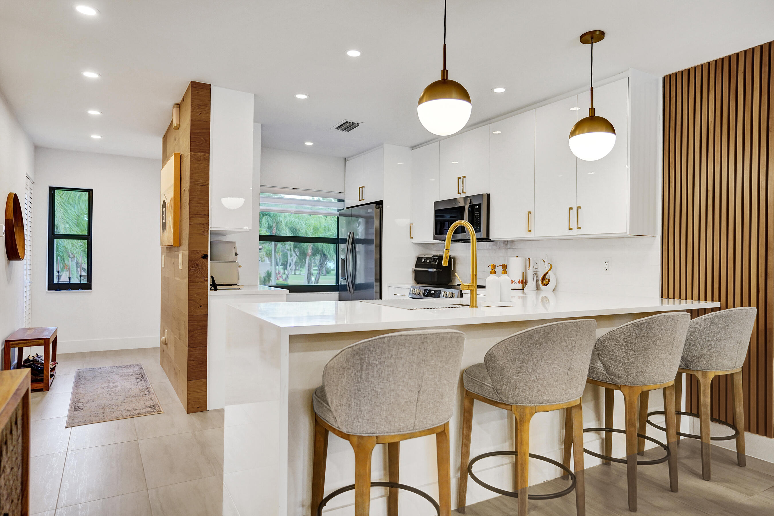 9293 Vista Del Lago, Unit 15F Boca Raton, FL 33428 - Photo 1 of 42 a kitchen with stainless steel appliances granite countertop a table chairs and a refrigerator