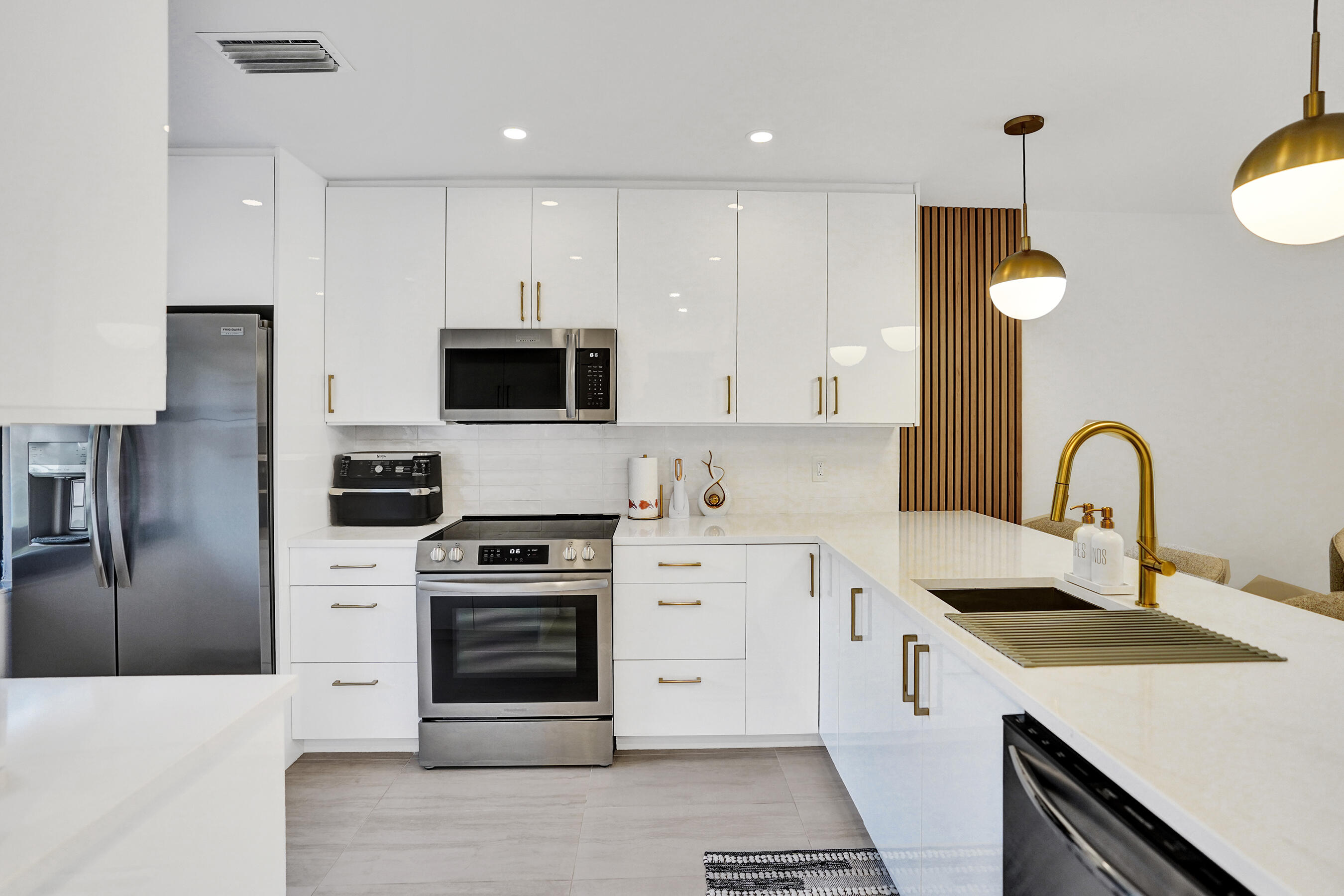 9293 Vista Del Lago, Unit 15F Boca Raton, FL 33428 - Photo 2 of 42 a kitchen with white cabinets and stainless steel appliances