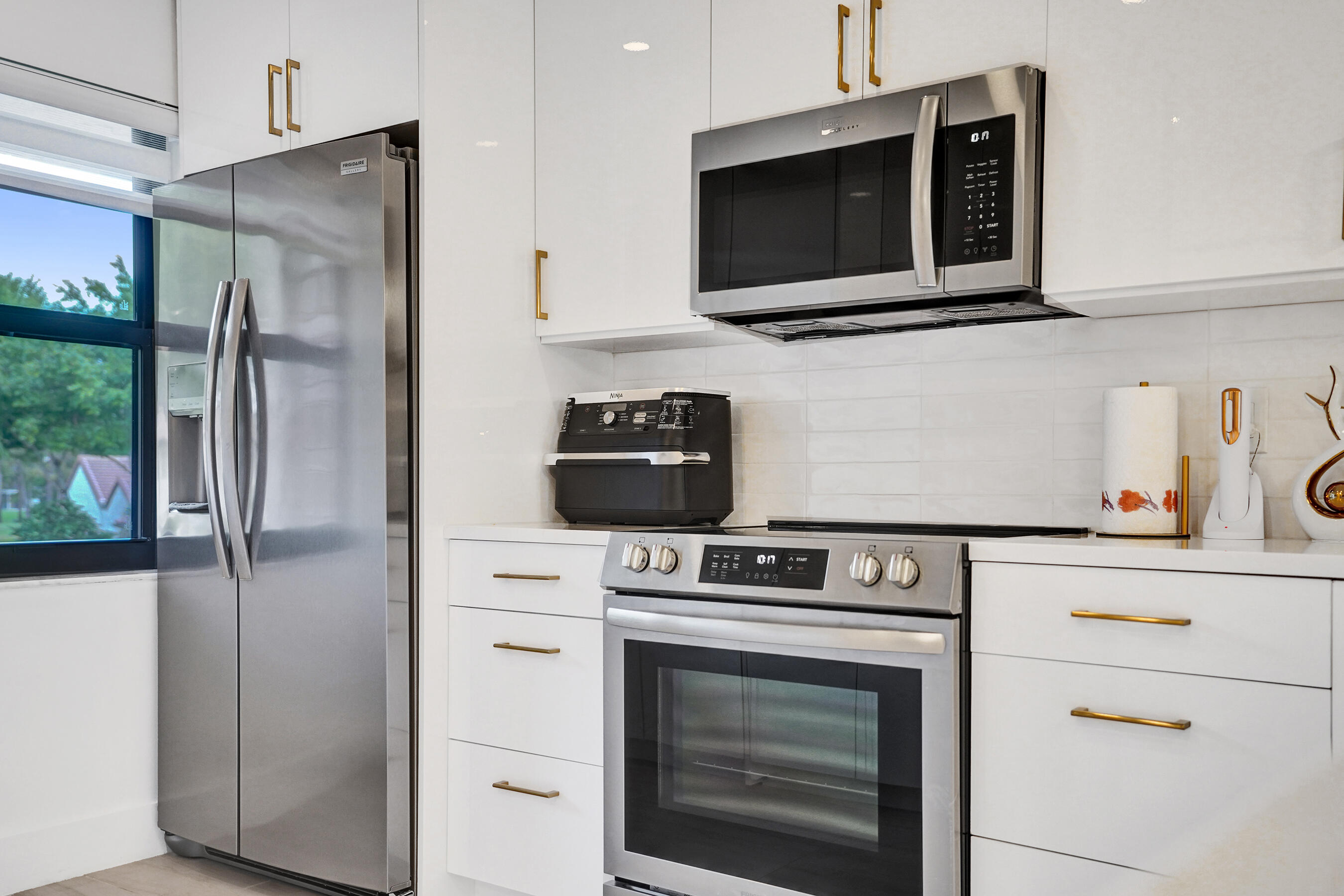 9293 Vista Del Lago, Unit 15F Boca Raton, FL 33428 - Photo 3 of 42 a kitchen with stainless steel appliances white cabinets and a stove