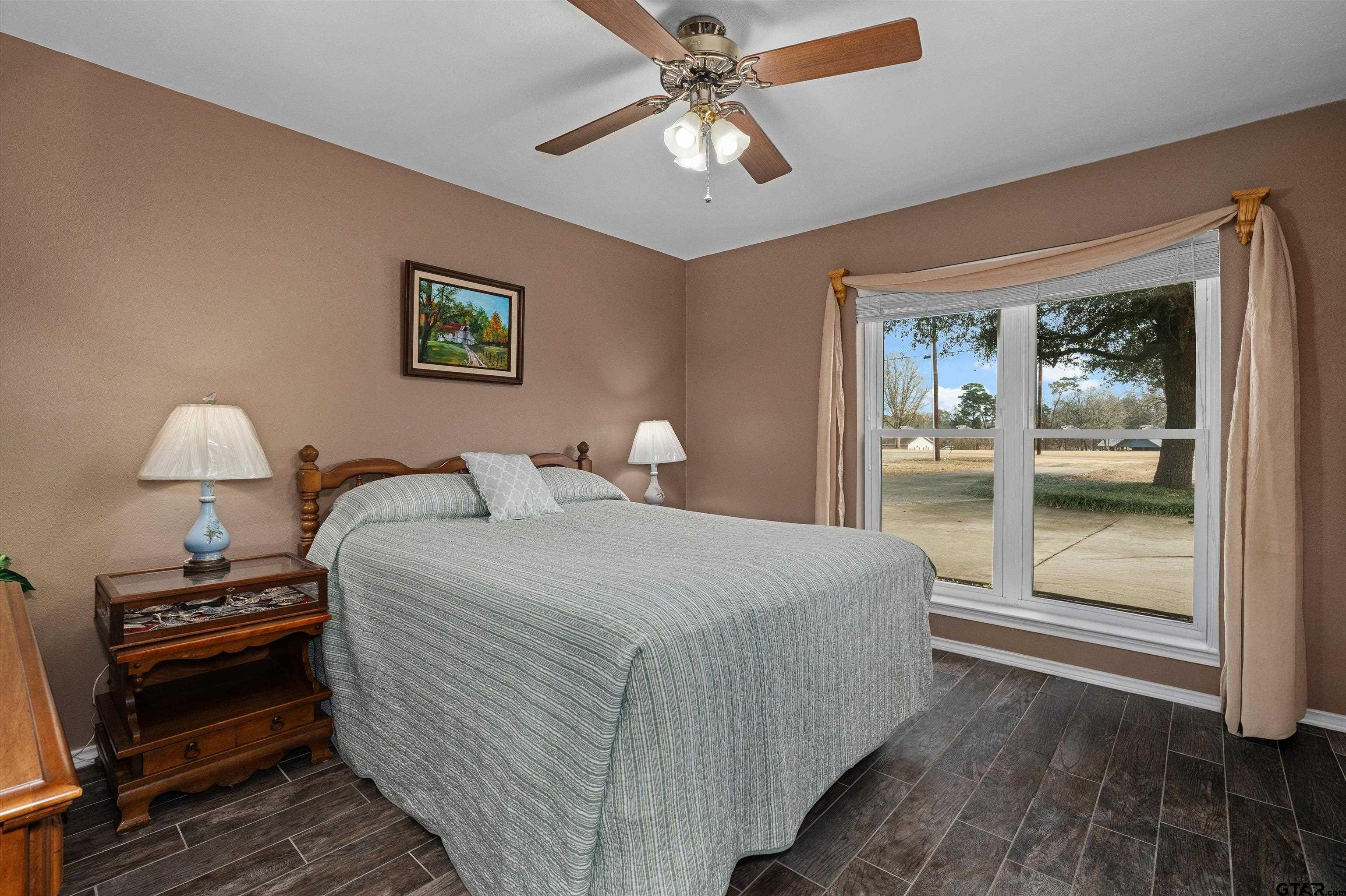 20 County Road 2938 South Pittsburg, TX 75686 - Photo 20 of 27 a bedroom with bed and a chandelier