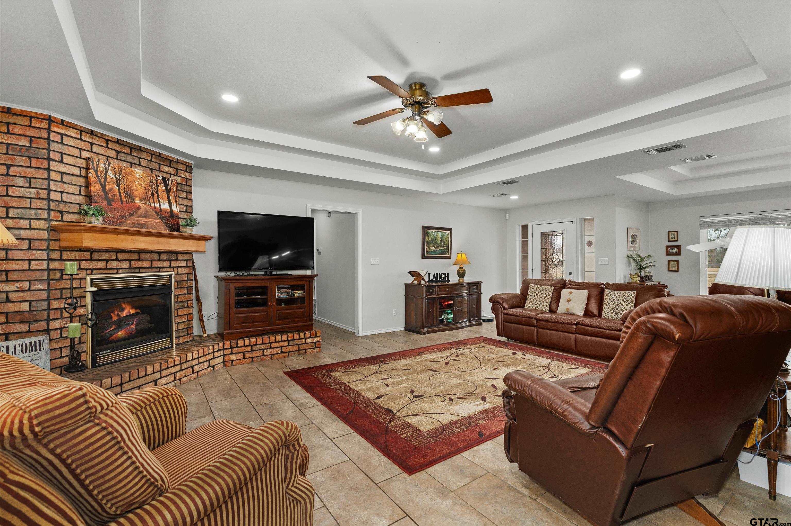20 County Road 2938 South Pittsburg, TX 75686 - Photo 4 of 27 a living room with furniture a fireplace and a flat screen tv