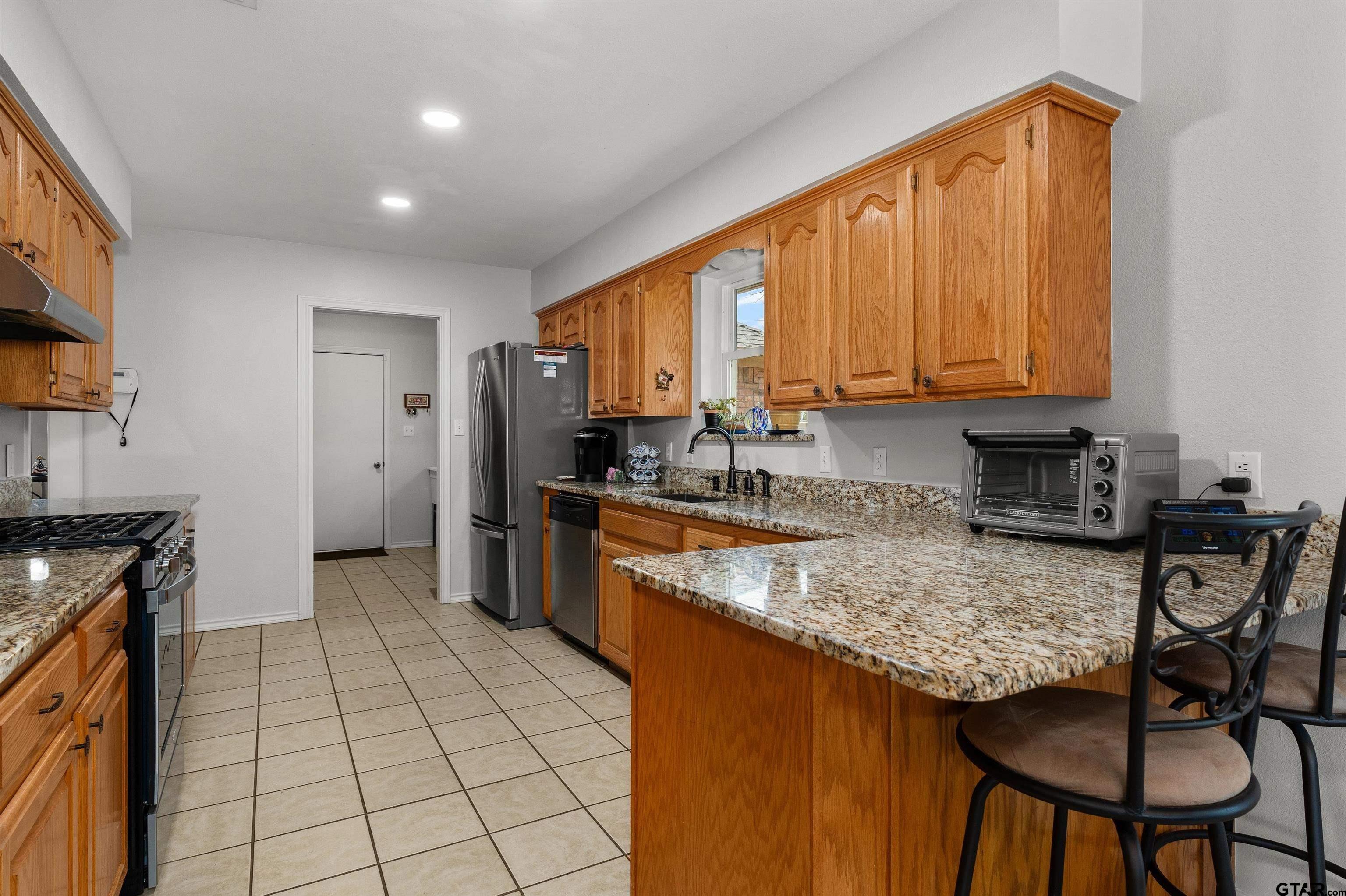 20 County Road 2938 South Pittsburg, TX 75686 - Photo 8 of 27 a kitchen with stainless steel appliances granite countertop a stove a sink and a refrigerator