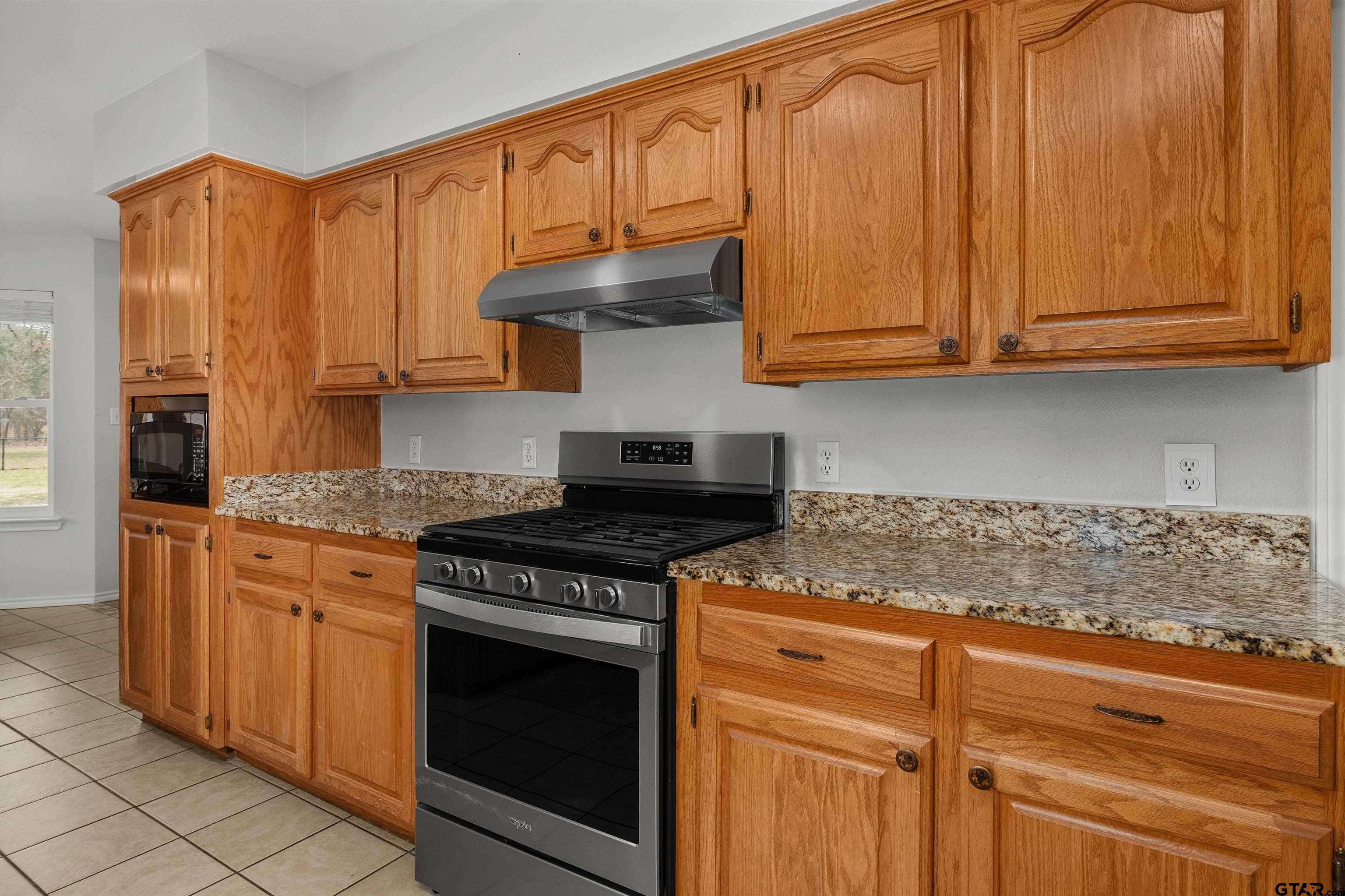 20 County Road 2938 South Pittsburg, TX 75686 - Photo 9 of 27 a kitchen with stainless steel appliances granite countertop a stove a sink and a microwave