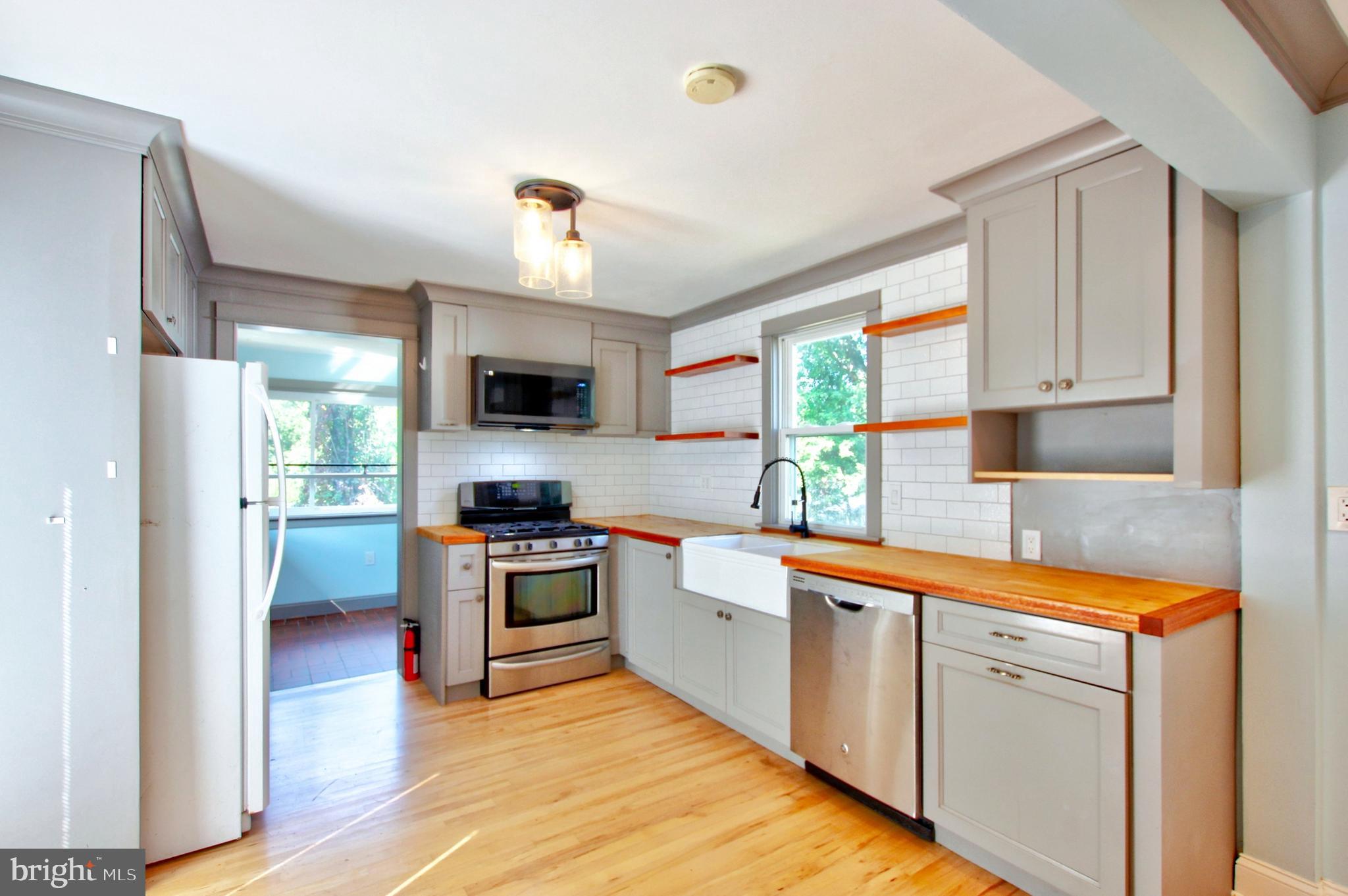 11808 Goodloe Road Silver Spring, MD 20906 - Photo 14 of 57 a kitchen with white cabinets and stainless steel appliances
