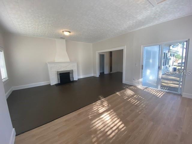 373 East Waldo Street Groveland, FL 34736 - Photo 11 of 23 a view of an empty room with wooden floor fireplace and a window