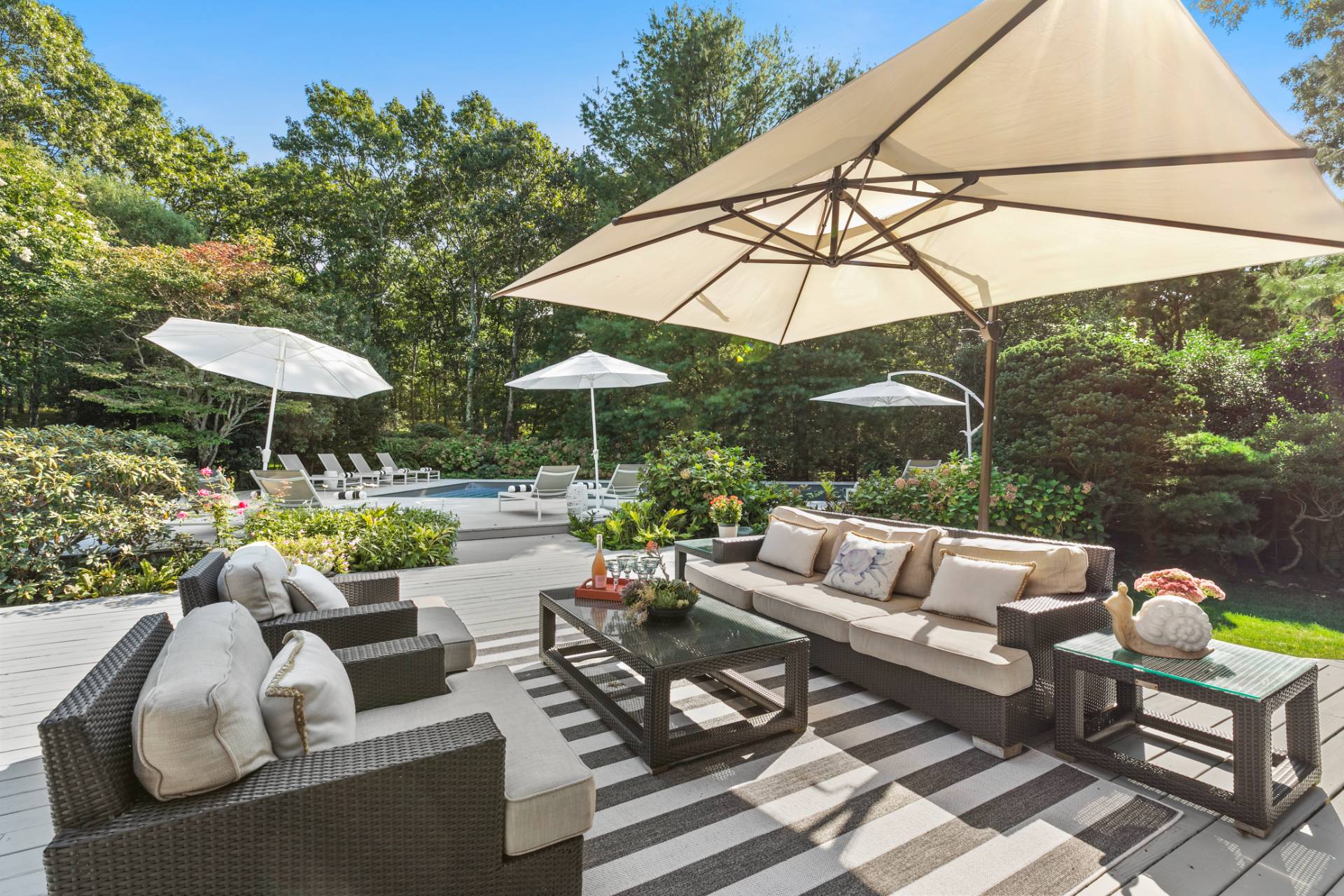570 Rte 114 East Hampton, NY 11937 - Photo 27 of 30 a view of patio with couches table and chairs under an umbrella