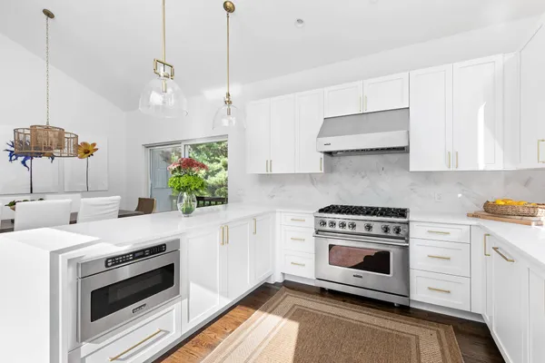 a kitchen with stainless steel appliances white cabinets and a stove