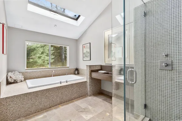 a bathroom with a tub a sink and mirror